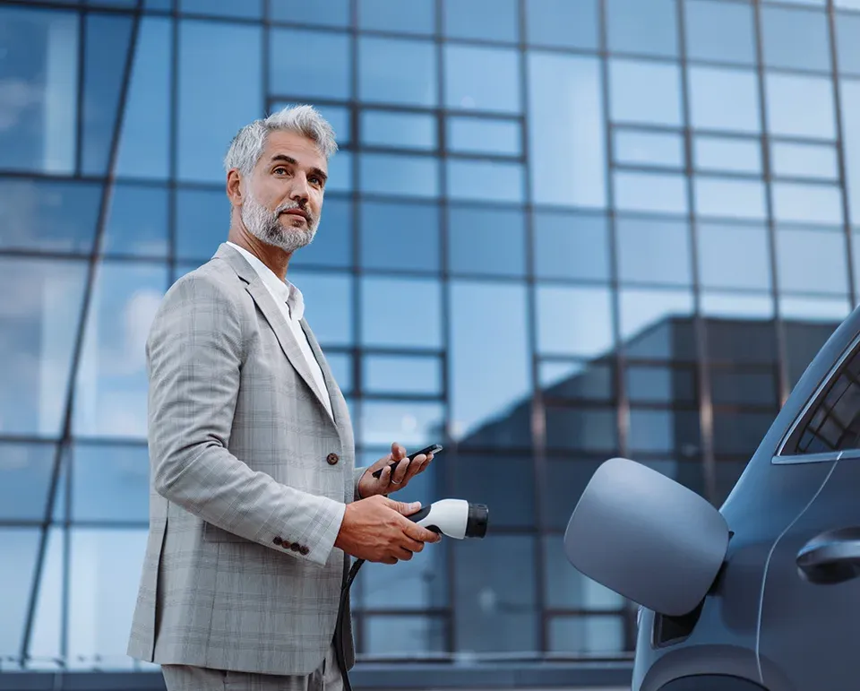 Gesch&auml;ftsmann im Anzug l&auml;dt Firmenfahrzeug der Firmenflotte auf
