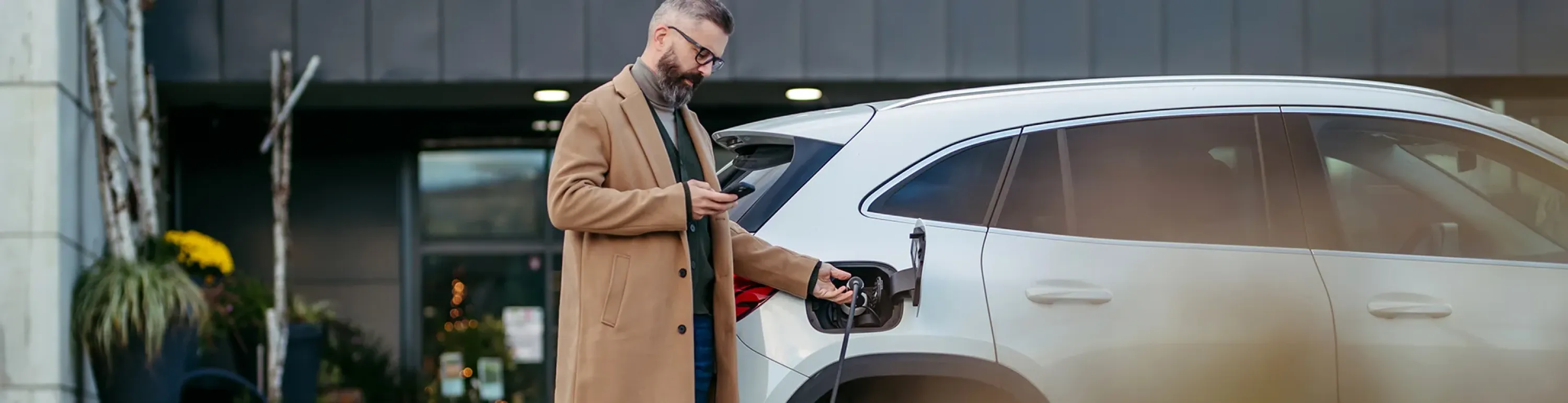 Gesch&auml;ftsmann l&auml;dt E-Auto auf &Uuml;bersicht Elektromobilit&auml;t