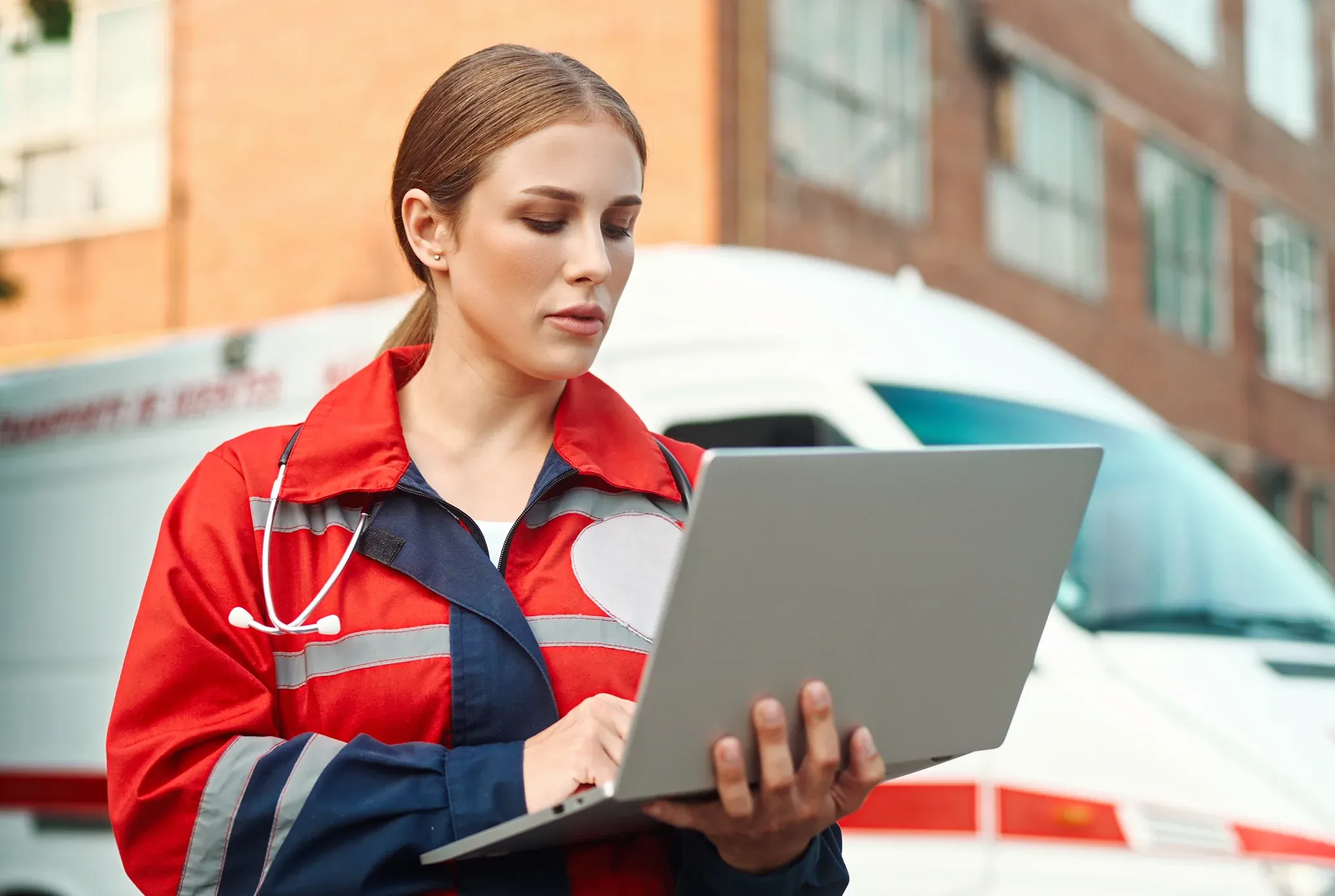 Rettungssanit&auml;terin steht vor Volkswagen Rettungsfahrzeug
