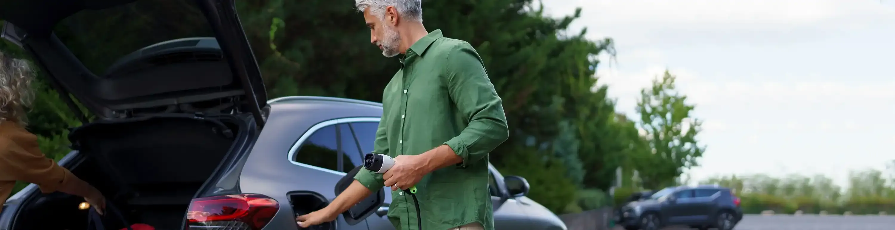 Mann l&auml;dt ganz einfach sein Elektroauto unterwegs auf